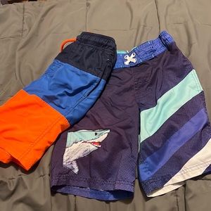 Two pairs of car and Jack boys swim trunks